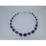 A modern silver necklace set with amethysts,