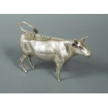 A Dutch metalwares silver semi naturalistic cow creamer,