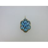 A pendant set with a cluster of blue topaz and yellow sapphires,