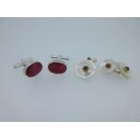 A pair of single ended ruby cufflinks together with a pair of mother-of-pearl and ruby cufflinks,