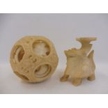 A well detailed alabaster or similar concentric ball and a carved stylised animal.