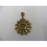 An unusual 9ct gold rosette shaped pendant with filigree decoration.