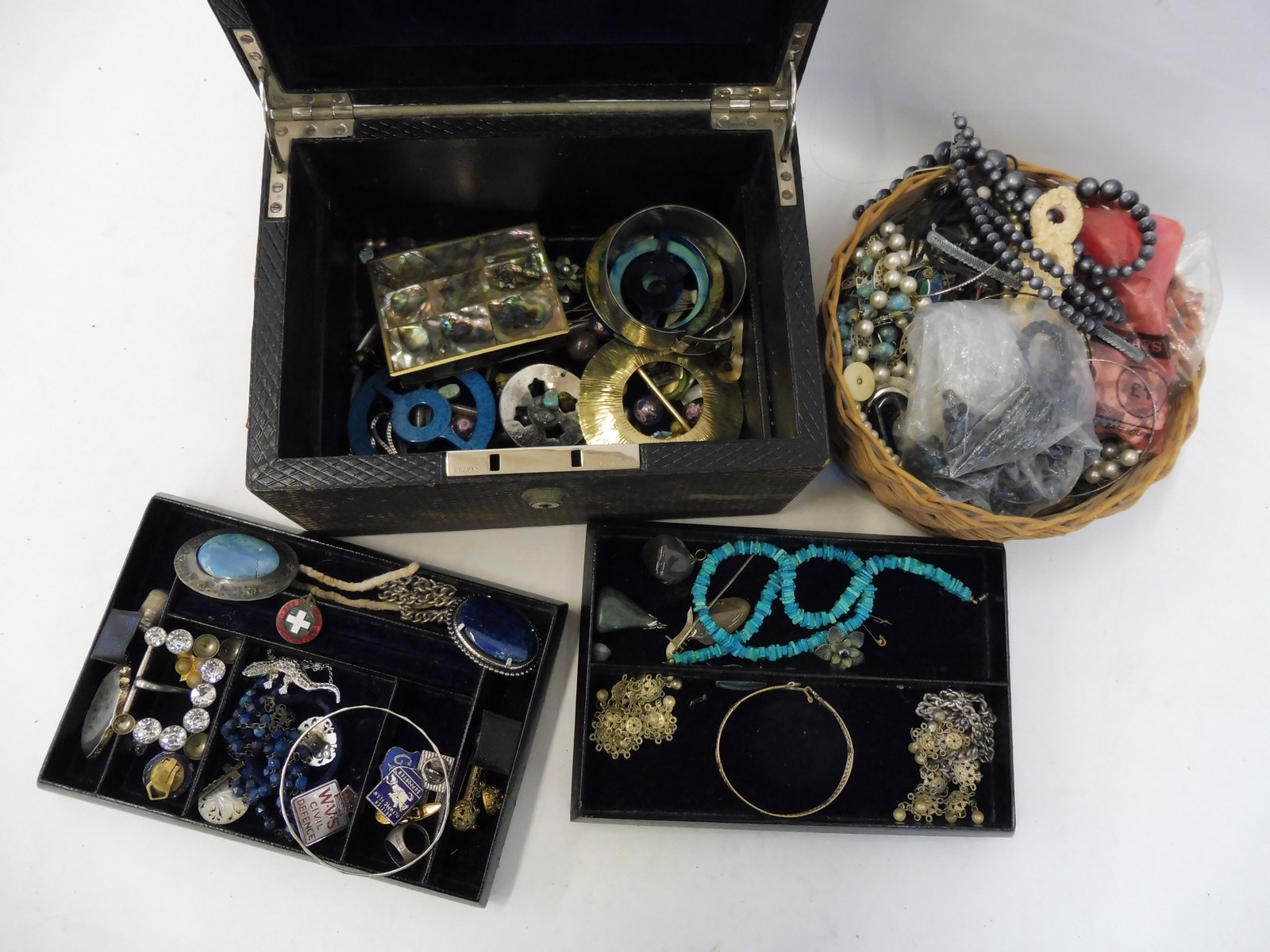 A jewellery box containing an assortment of costume jewellery and a small basket of necklaces etc.