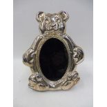 A contemporary silver fronted easel photograph frame in the shape of a teddy bear