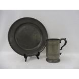 An 18th Century pewter charger, possibly Dutch and an early pewter quart tankard.