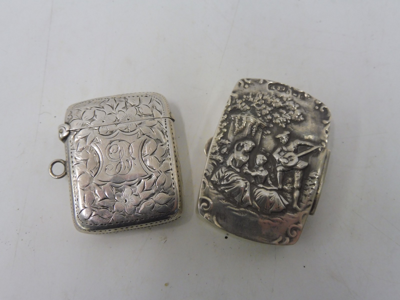 A sterling silver pill pot, the lid in deep relief depicting figures and a silver vesta case.