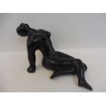 An unusual art pottery sculpture of a stylised recumbant female nude.