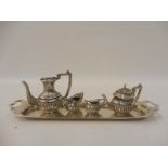 A miniature silver four piece half fluted tea set on a rectangular tray.