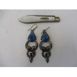 A pair of unusual silver earings set with turquoise coloured stones, and a silver and MOP handled