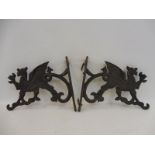 A pair of cast metal stylised dragon wall brackets.