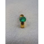 A 22ct gold ring set with a green stone.