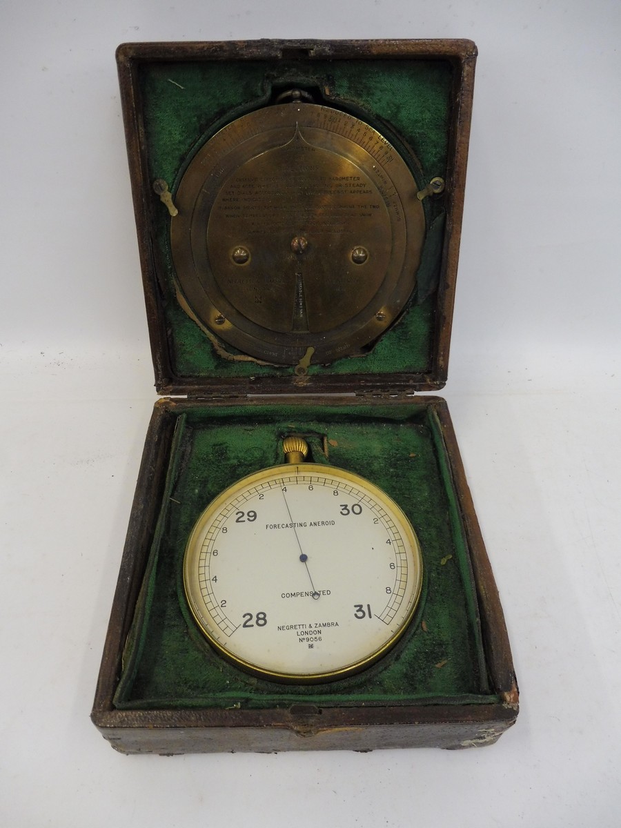 A gilt brass Negretti & Zambra of London aneroid barometer and a brass weather forecasting