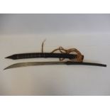 An Eastern curved sword with wooden and brass bound sheath.