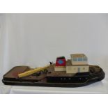 A large wooden model of a tug boat.
