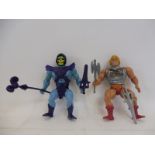 A He Man figure and Skeletor pair of stiff limbed figures, weapons present.