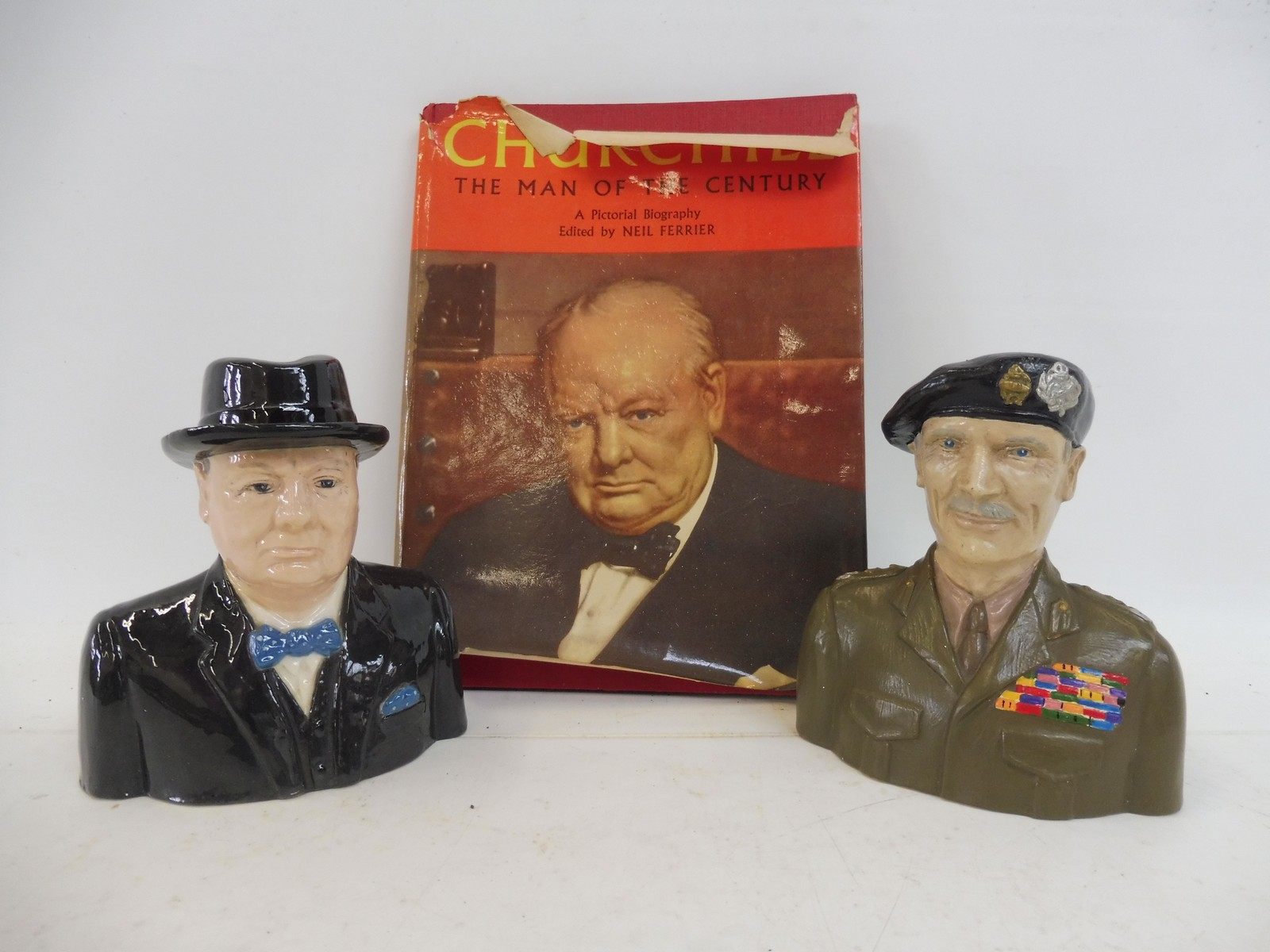 A glazed pottery character jug of Winston Churchill, another of Montgomery plus a single volume -