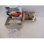 A 1/25 scale model kit of an MPC Dukes of Hazard General Lee and a sealed AMT Munsters Koach.