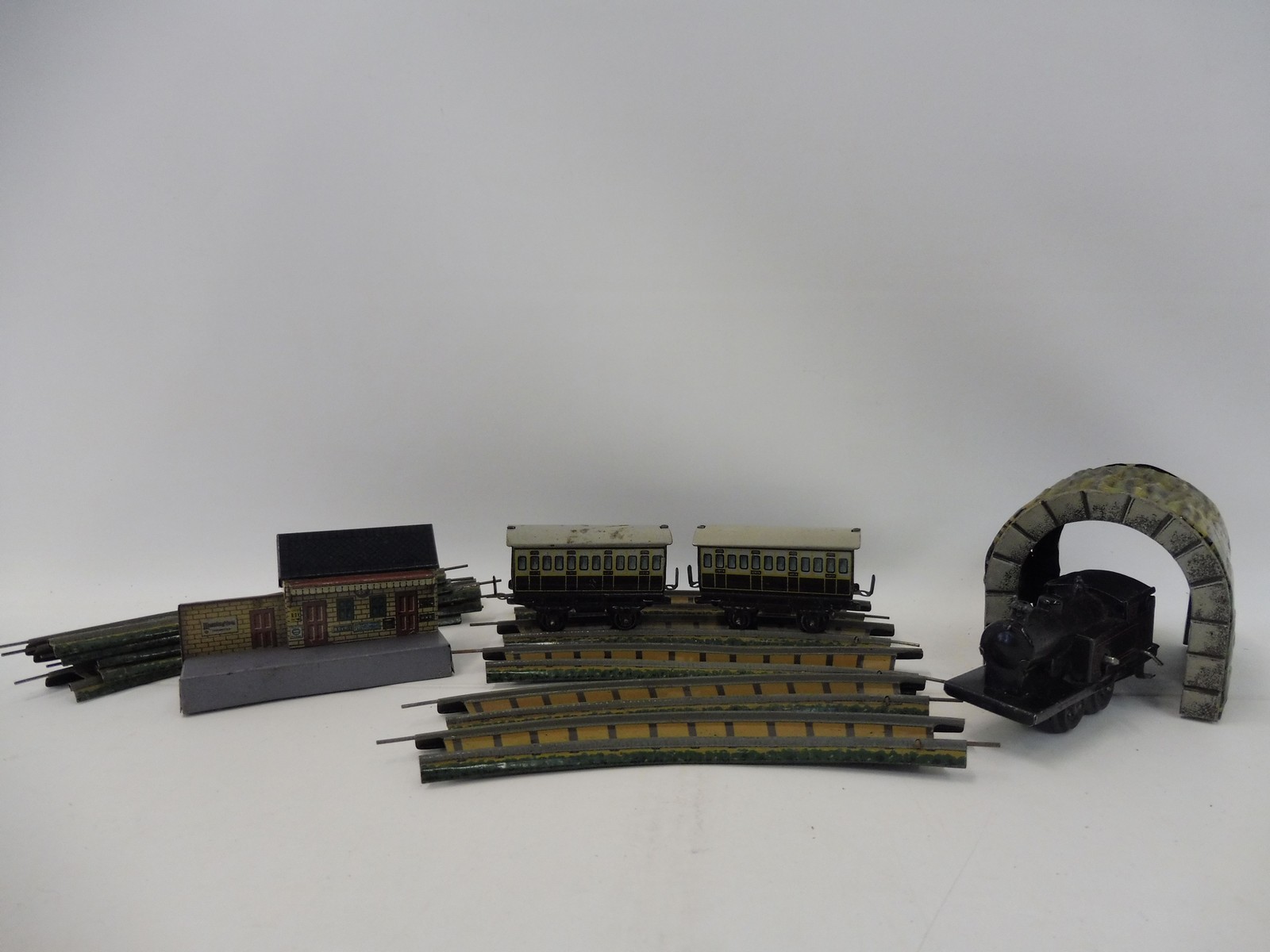 A German tinplate clockwork part train set, possibly Bing comprising a locomotive, two carriages,