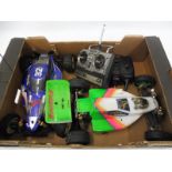 Two Kyosho 4WD belt driven (battery) remote controlled off-road cars plus two controllers.