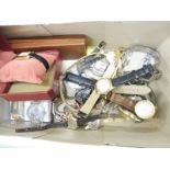 A shoe box of assorted watches.