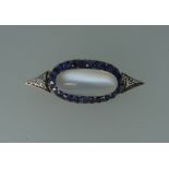 An attractive Brooch, the centre set with a oval moonstone, approx. 16.24ct, surrounded by twenty-