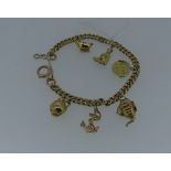 A 9ct yellow gold link Bracelet, with six 9ct yellow gold charms attached, including teapot, imp,