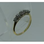 A small graduated five stone diamond Ring, mounted in white metal with a yellow metal shank, Size