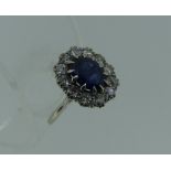 A synthetic sapphire and diamond cluster Ring, the central facetted synthetic sapphire, scratched