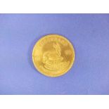 A 1oz Fine Gold Krugerrand coin, dated 1974, weight 33.9g.