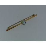 A 9ct yellow gold Bar Brooch, the centre set with a facetted rectangular aquamarine.