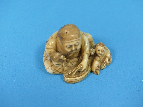 A 19th century Japanese carved ivory Netsuke, depicting a man and boy with a small bird, signed on - Image 4 of 4