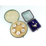 A cased set of six mother of pearl Buttons, within an unmarked rose colour metal surround, in velvet