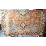 Tribal Rugs; an antique Persian Heriz rug, the orange ground with indigo medallion, pale blue and