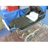 A Silver Cross Pram together with 8 Costume Dolls, pram is in good condition and has period bedding,