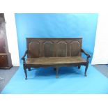 An early George III oak Settle, with ogee field panelled back, scrolled arms and cabriole legs