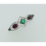 An attractive Brooch, formed of an open framework with a central millegrain set emerald, an oval