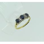 A sapphire and diamond Ring, the three facetted graduated oval sapphires with three small vertical
