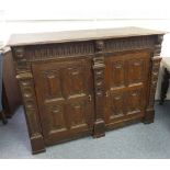 An antique carved oak Cupboard, the rectangular top with moulded edge above a carved frieze, two