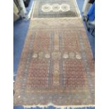 Tribal Rugs; an old Persian rug with Tekke design within a geometric border on mottled puce-coloured