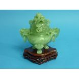 A Chinese sage green jade Koro and Cover, carved in relief with a two dragon masks, the sides with