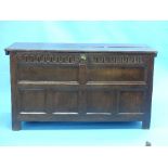 A 17th century oak Coffer, the hinged planked lid above a carved frieze and panelled front and