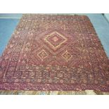 Tribal Rugs; a red ground Sumak rug with diamond shaped designs set in a geometric border, 100in x