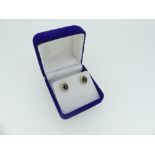 A pair of sapphire and diamond cluster Earrings, the central facetted oval blue sapphire