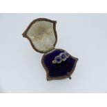 A three stone sapphire Ring, each stone surrounded by small diamonds, the unmarked gold shank with