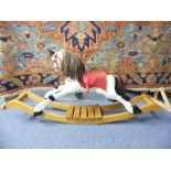 A Painted Wood Rocking Horse on Bow Rockers, with brown horse haired tail and mane, red leather