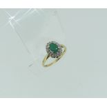 A small oval emerald and diamond cluster Ring, the shank in yellow gold marked 375, Size N, together