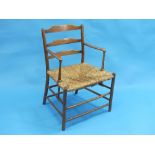 An antique provincial elm and ash ladder back Arm Chair, with rush seat.