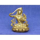 An antique Tibetan gilt bronze of Manjusri holding the Sword of Wisdom,