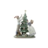 A Lladro porcelain figure group of two children decorating a Christmas Tree