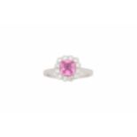 A pink sapphire and diamond cluster ring, set with an octagonal-cut pink sapphire